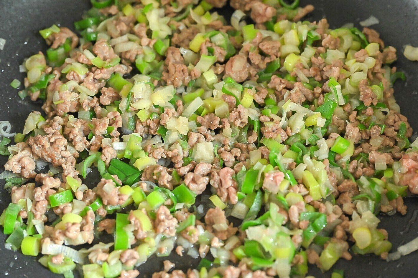 フライパンに入った炒めたひき肉と長ねぎ