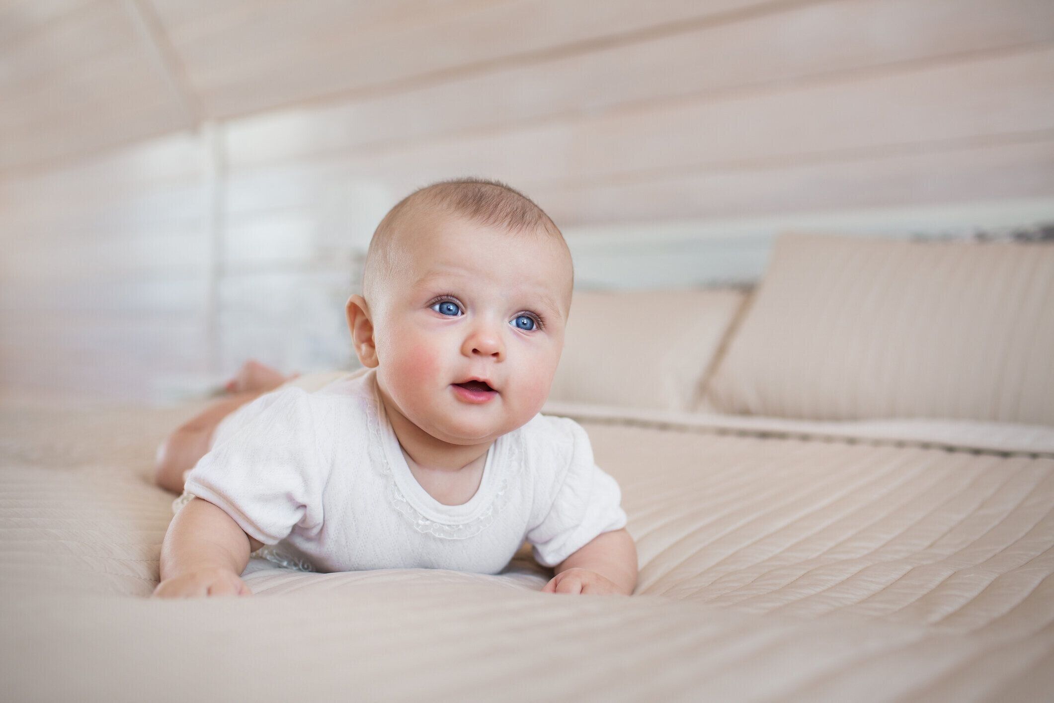 小さな赤ちゃんの肖像画があり、ベッドの上の笑顔