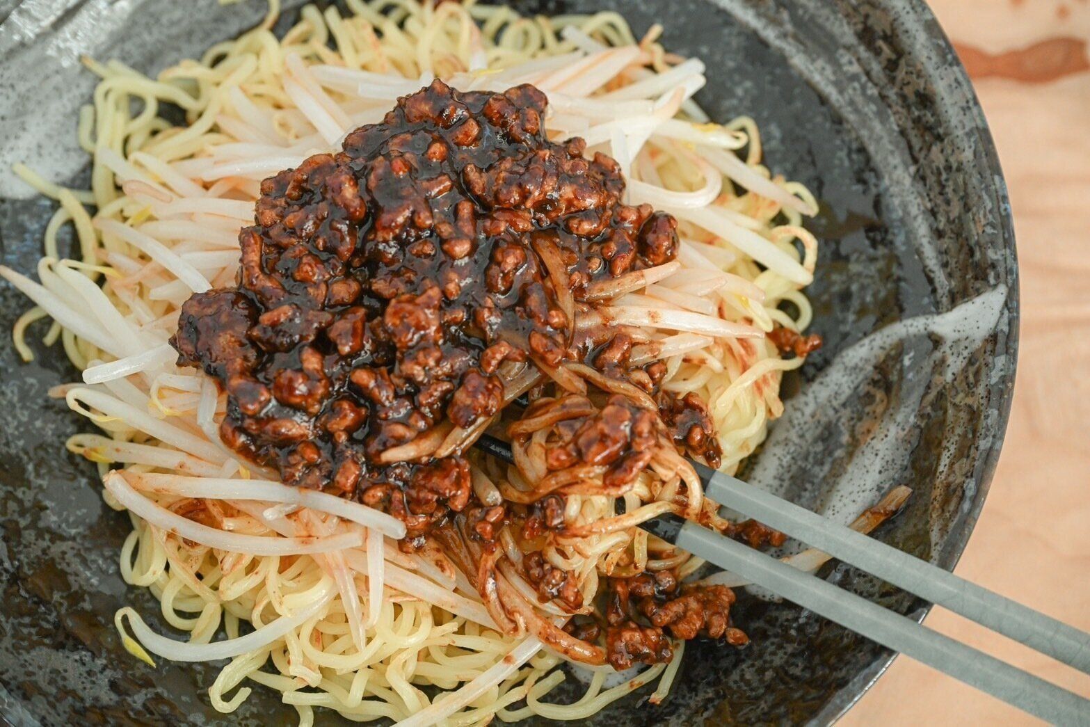 箸で混ぜている黒麻婆焼きそば