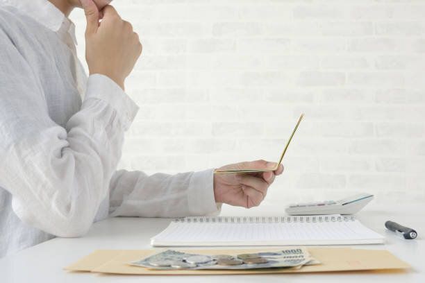 居間で通帳をチェックする女性