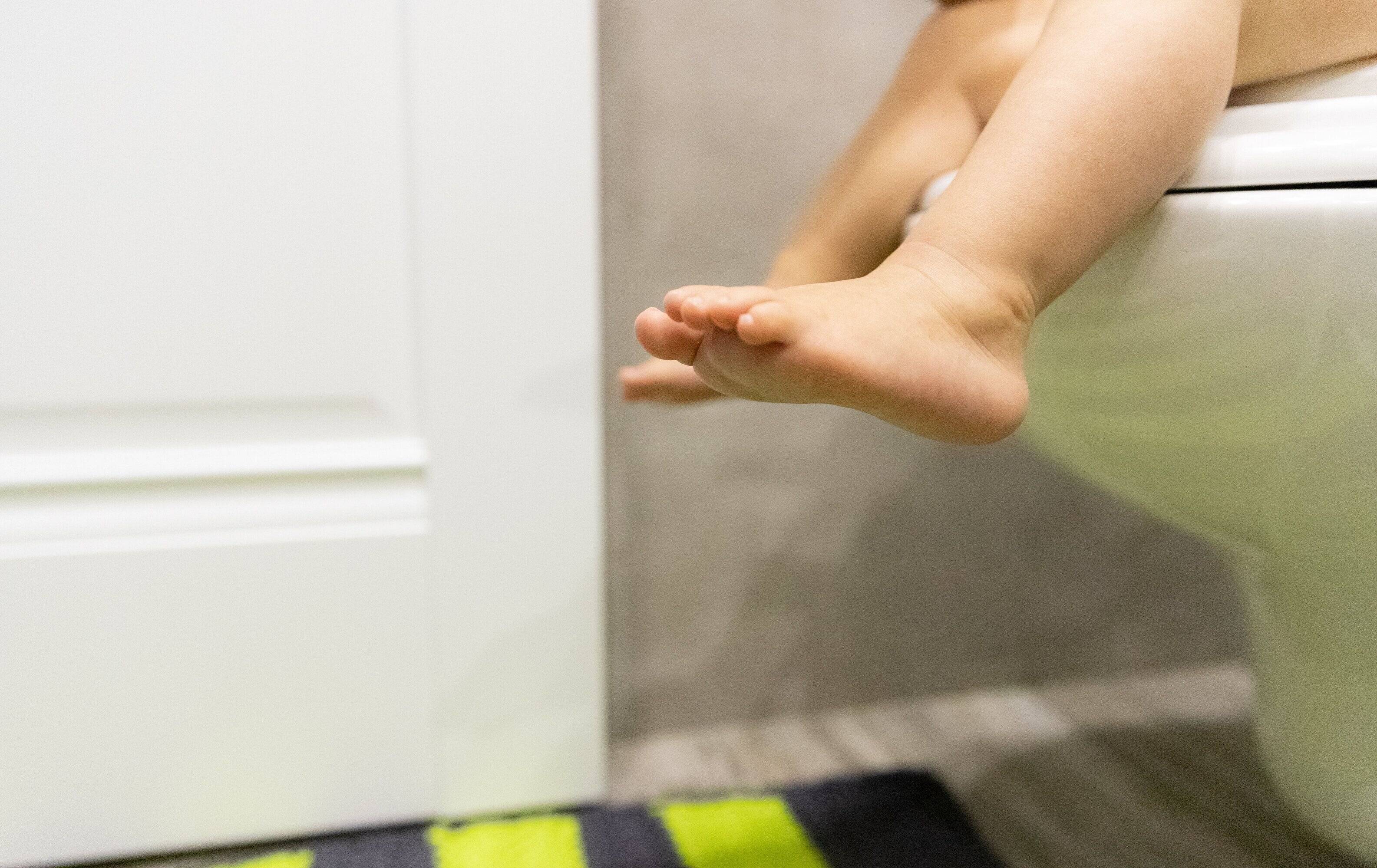 トイレに赤ちゃんの足。子供のコンセプトです。トイレ