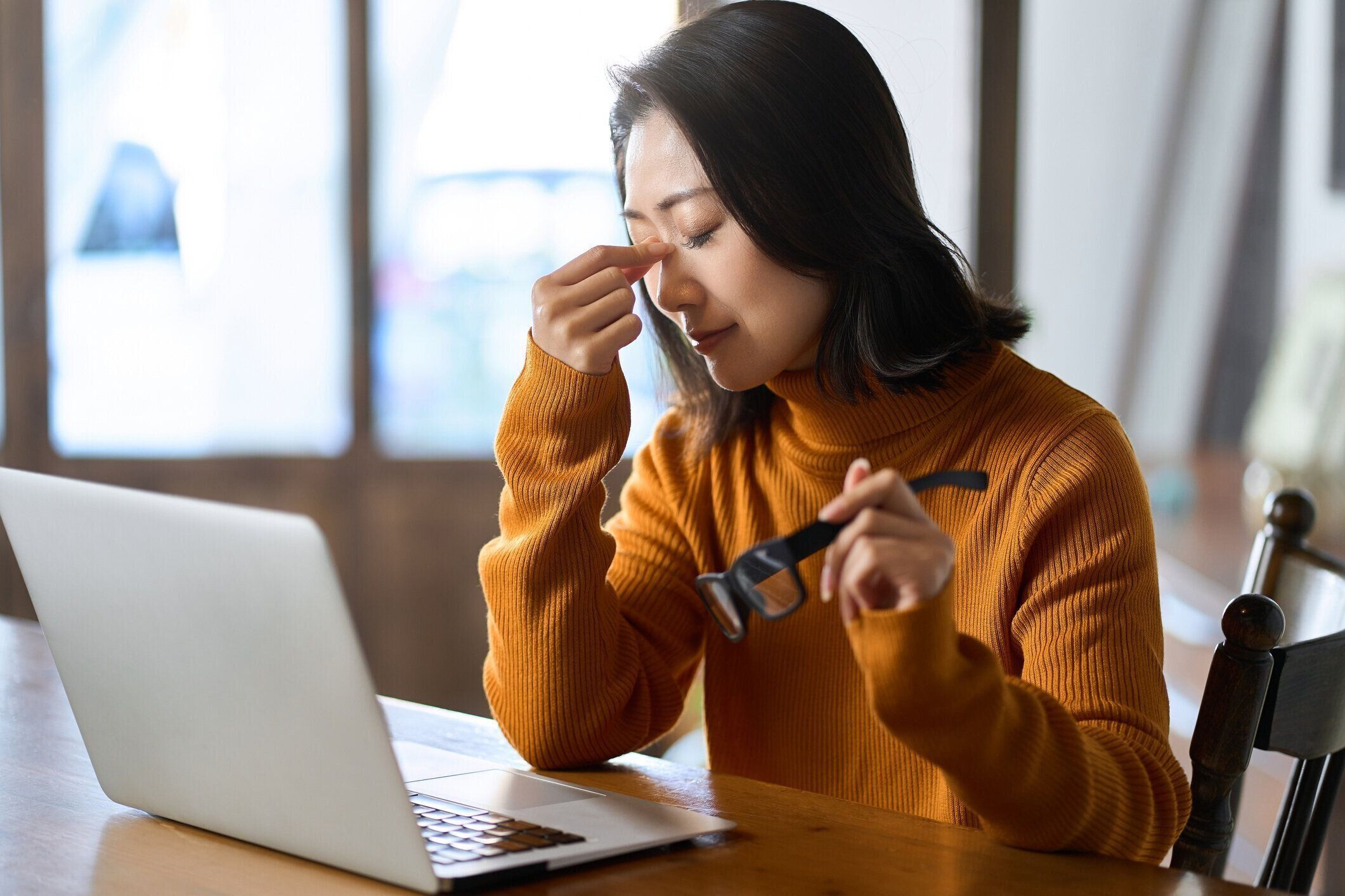 コンピューター作業で目が疲れている女性