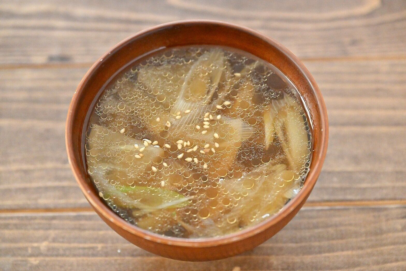 茶色のお椀に入った大根と長ねぎのスープ