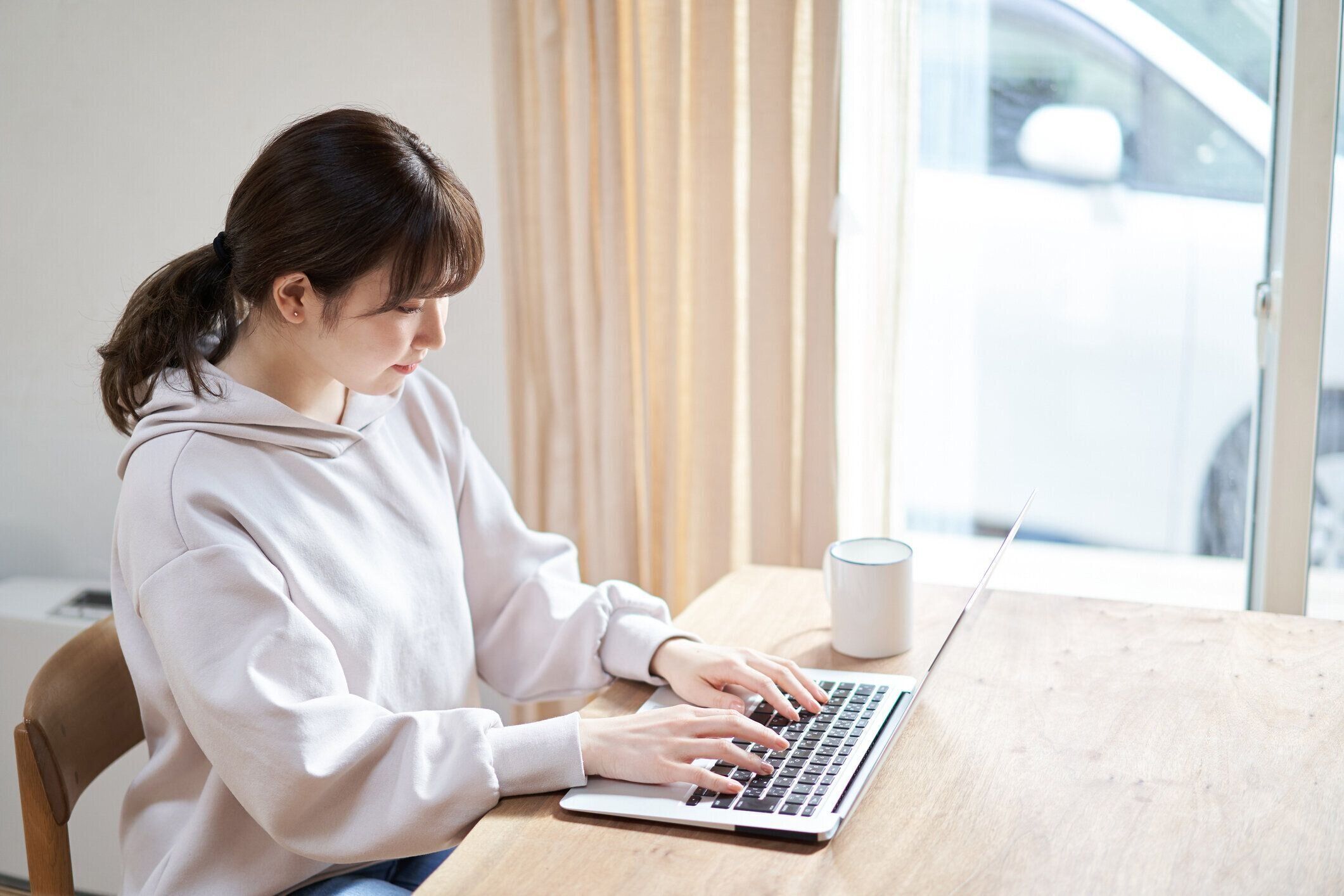 リビングルームでコンピュータで作業しているアジアの女性