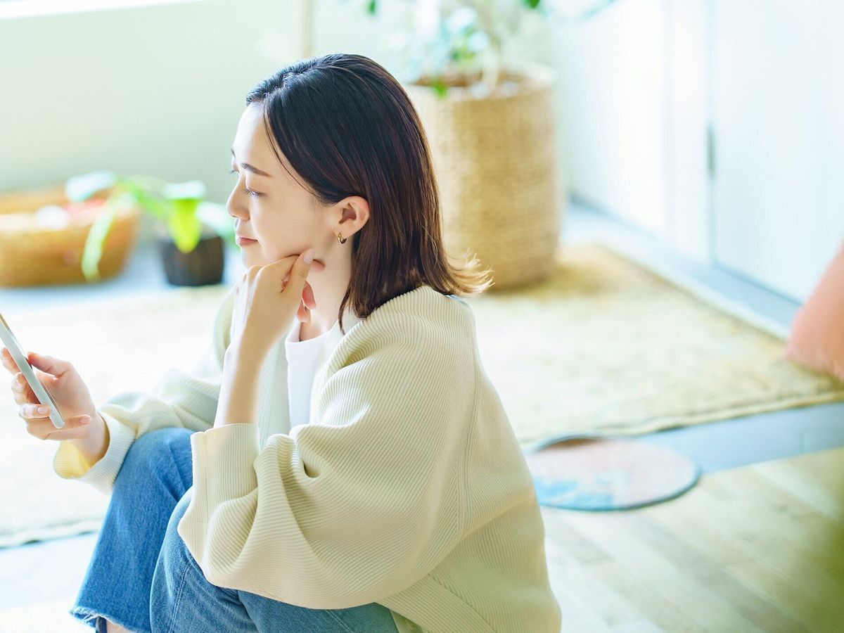 部屋でスマホを持っている女性