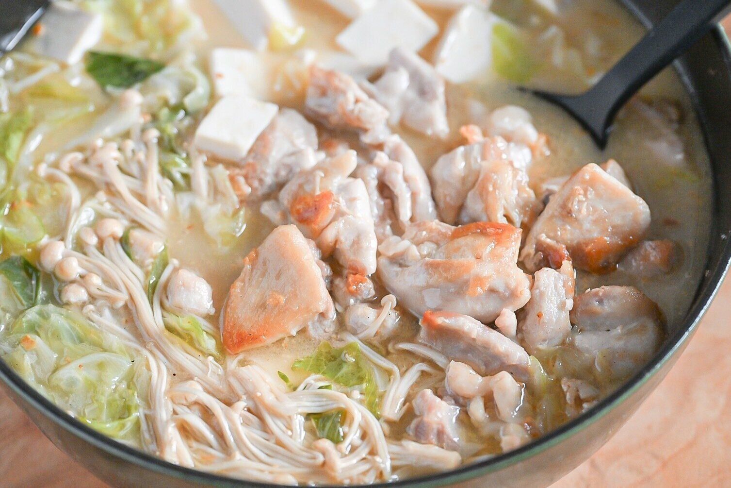 スプーンで持ち上げた鶏白湯鍋