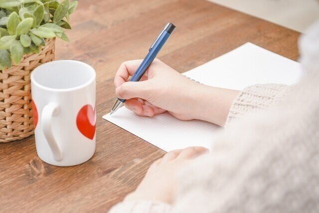 ノートにメモする女性