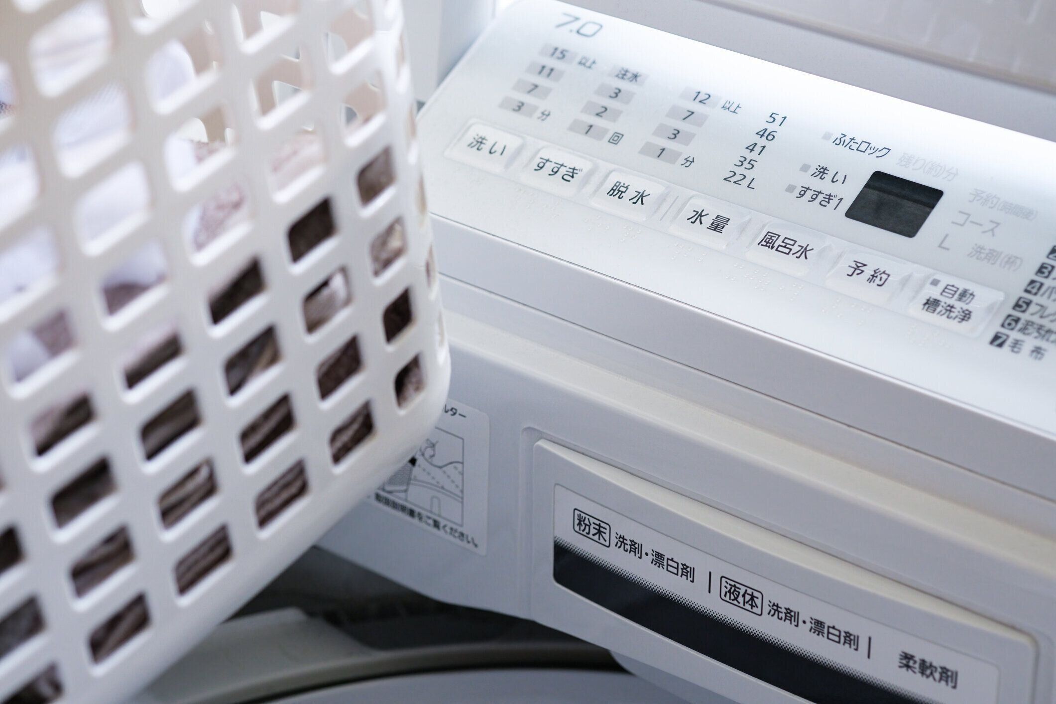 ランドリールーム内のランドリーバスケットと洗濯機