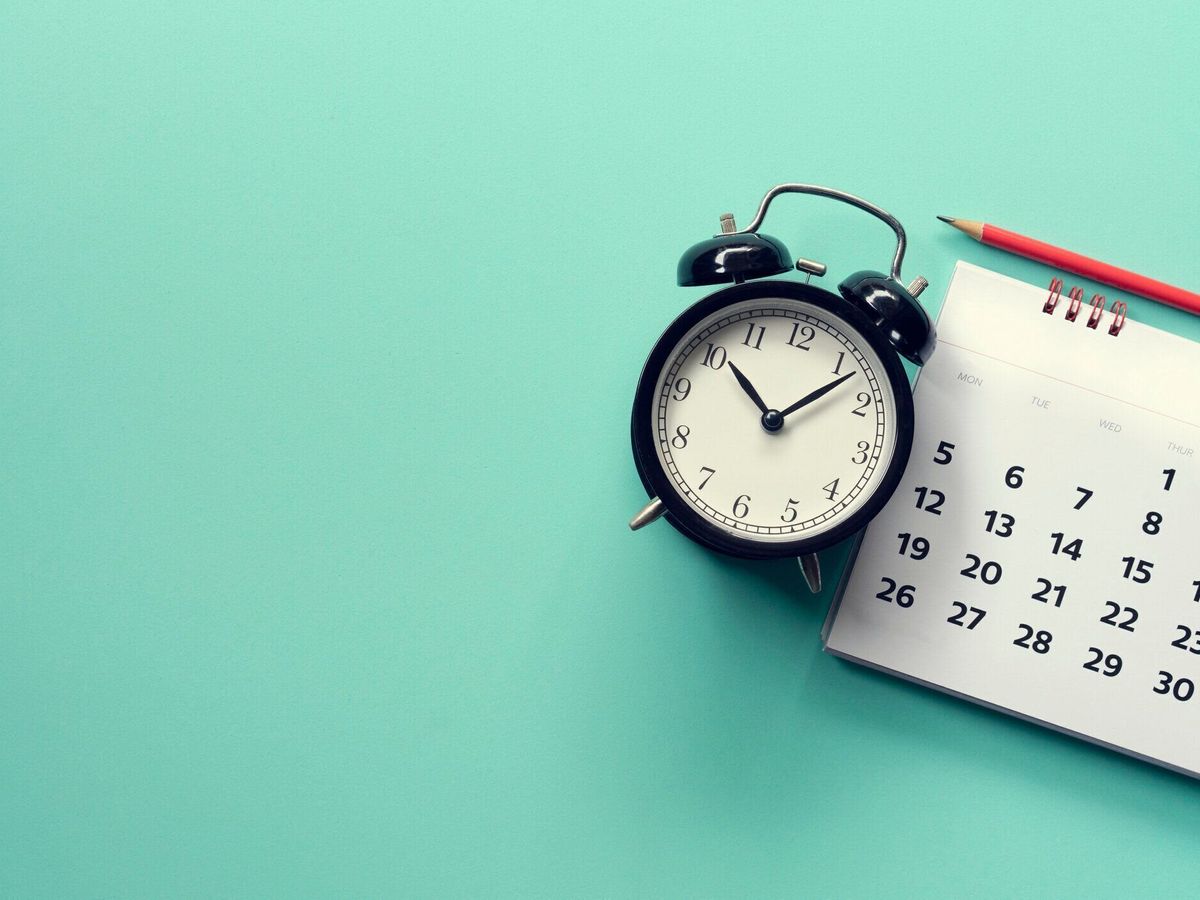 緑の背景にカレンダーと目覚まし時計のクローズアップ, ビジネスミーティングや旅行計画の概念のための計画