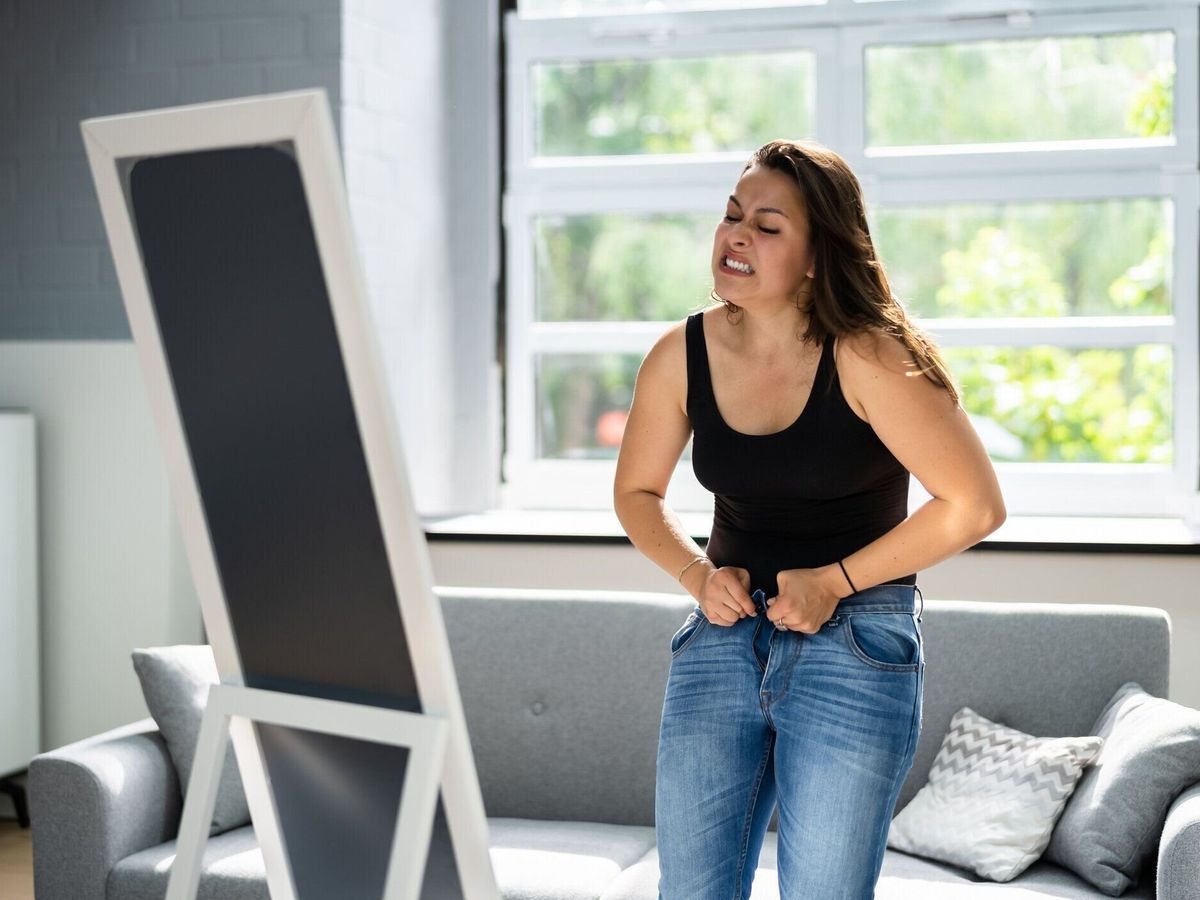 タイトなジーンズに苦しむ女性