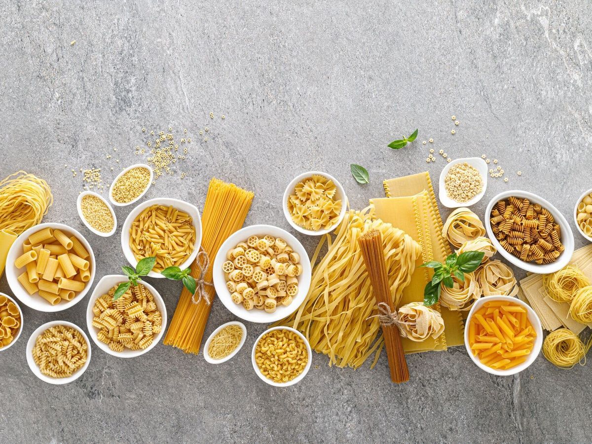 パスタ。石の背景の上に調理されていないパスタや麺の様々な種類、テキストのためのコピースペースとトップビュー。イタリア料理の料理コンセプト。調理テーブル上の異なる生パスタの�