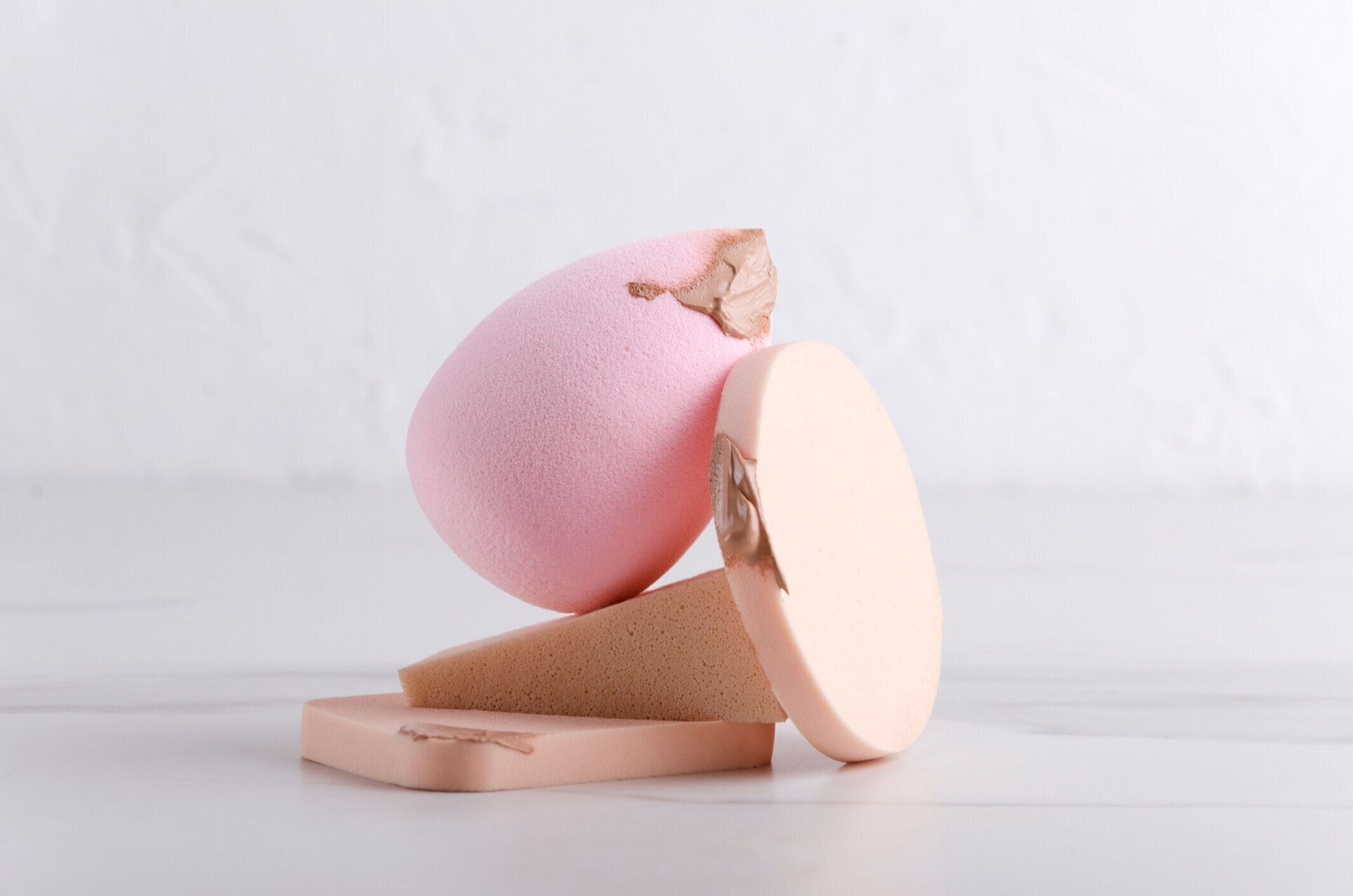 化粧品のスポンジとコンシーラーの塗りつぶし。化粧品スポンジのスタックのクローズアップ