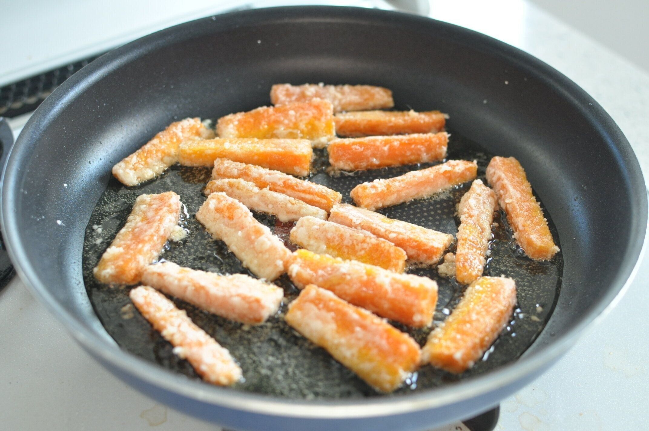フライパンでにんじんを揚げ焼きする様子
