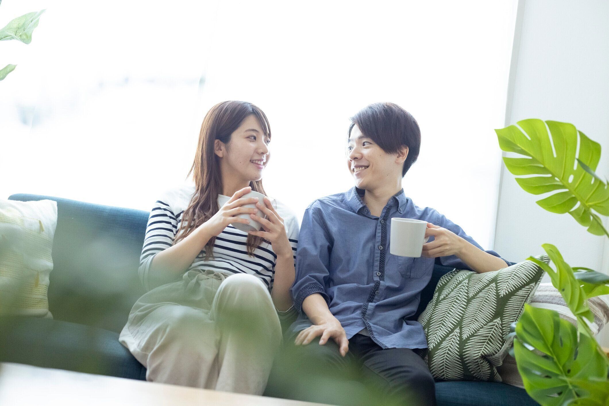 居間でリラックスした、見栄えの良い日本の男女