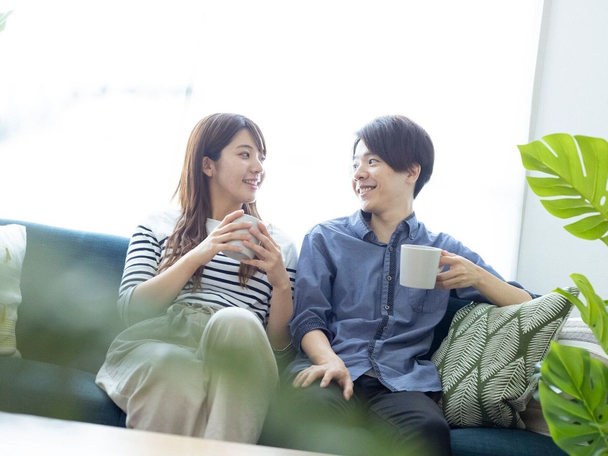 居間でリラックスした、見栄えの良い日本の男女