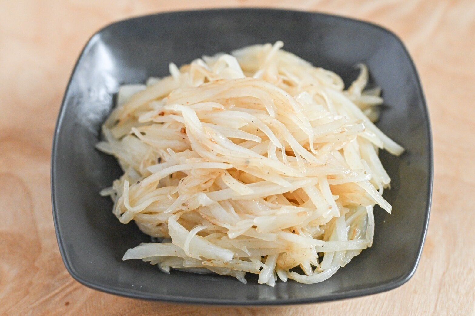 黒い皿に盛られたじゃがいも炒め