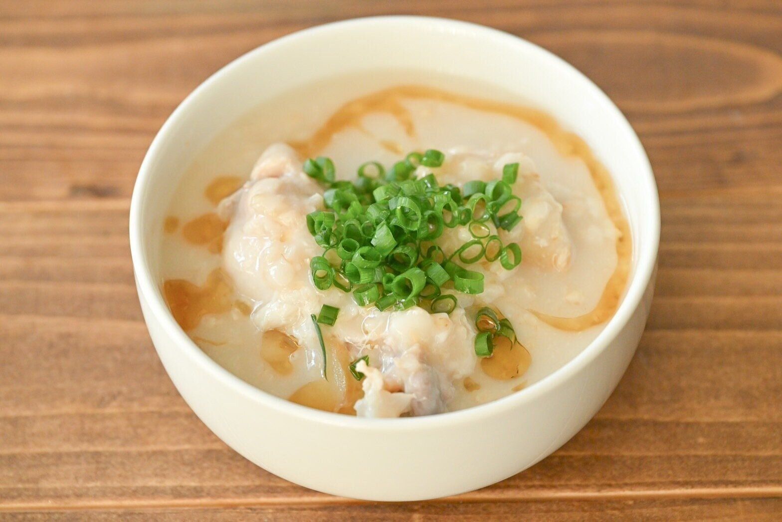 白い皿に入ったオートミールの鶏粥風