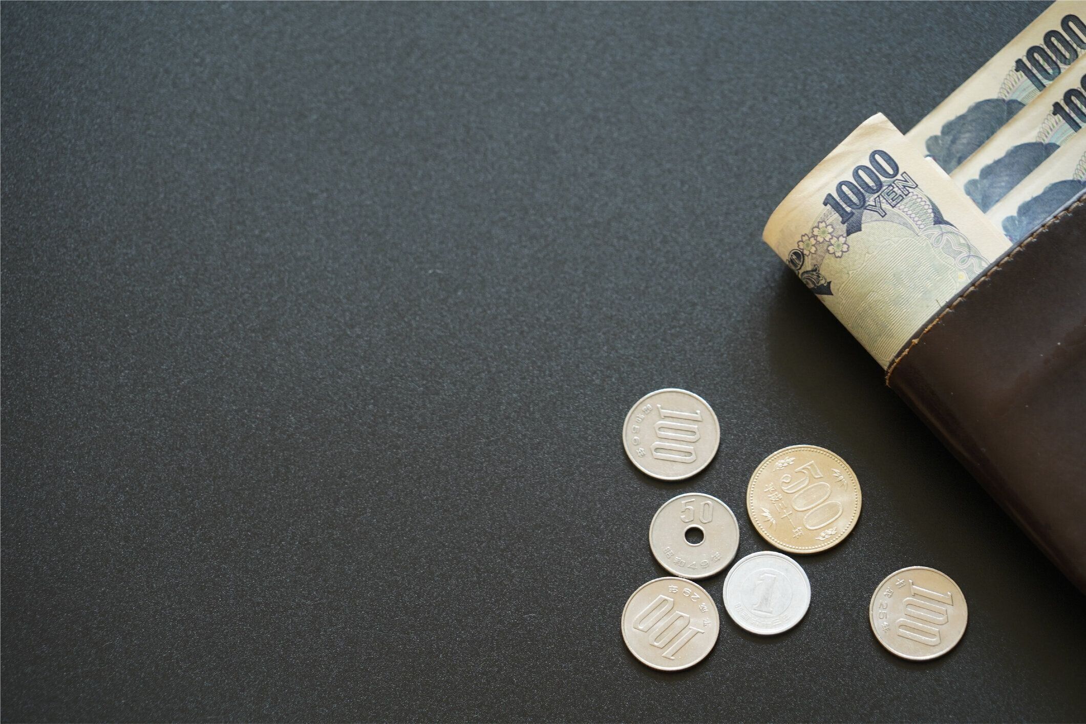 暗い背景、銀行経済金融概念、日本のお金の節約に財布の中の日本の紙幣とコイン