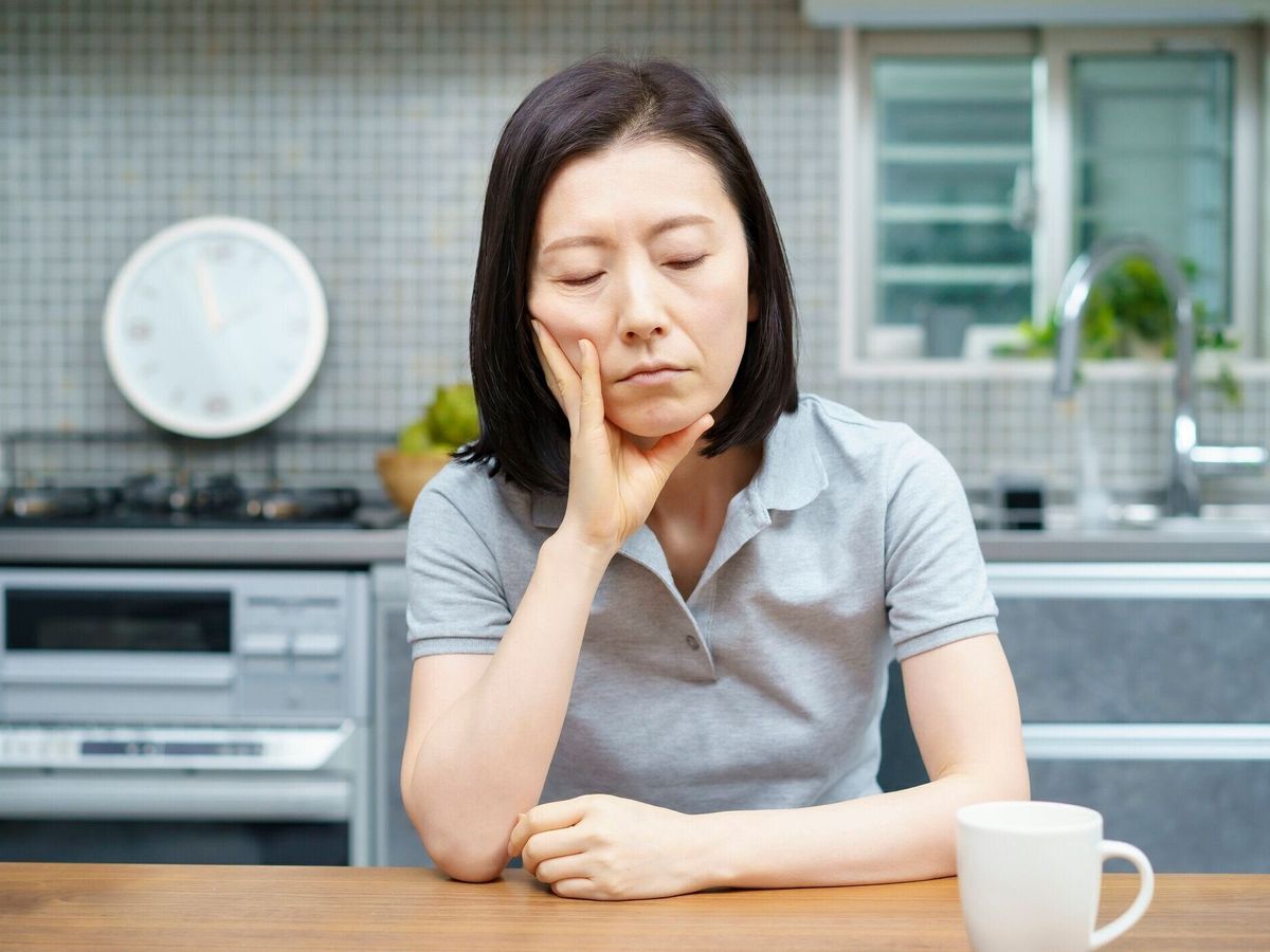 疲れた表情をした中年女性