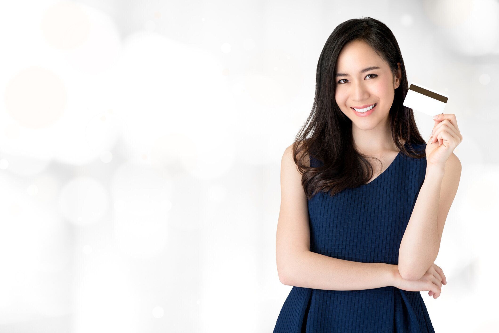 手にクレジット カードを提示若い笑顔の美しいアジア女性