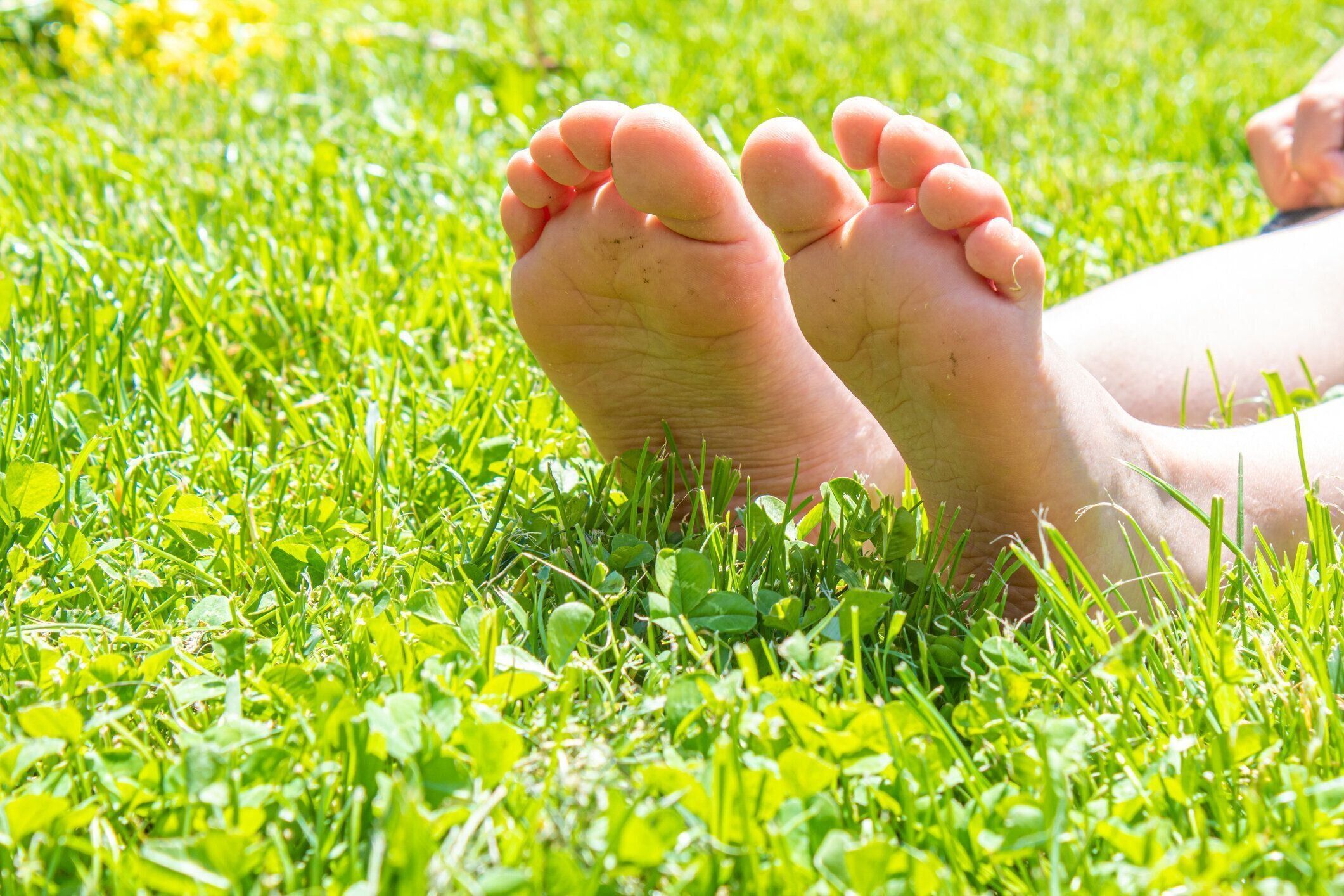 緑の草の上に横たわっている子供。春の公園で屋外で楽しい子供。選択的フォーカス。