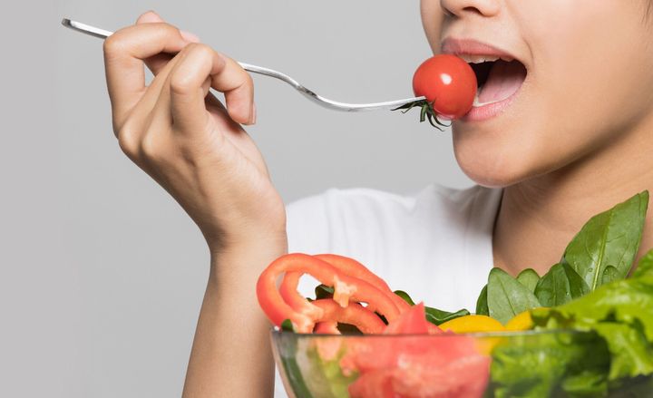 サラダを食べる若い女性。