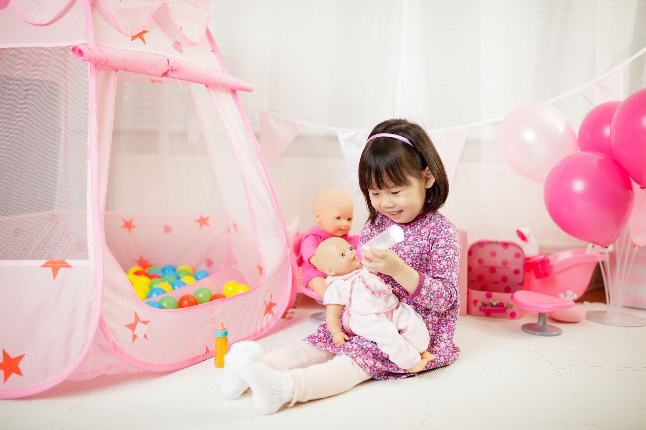 幼児の女の子は白い背景に対して自宅でベビーケアをプレイするふりをする