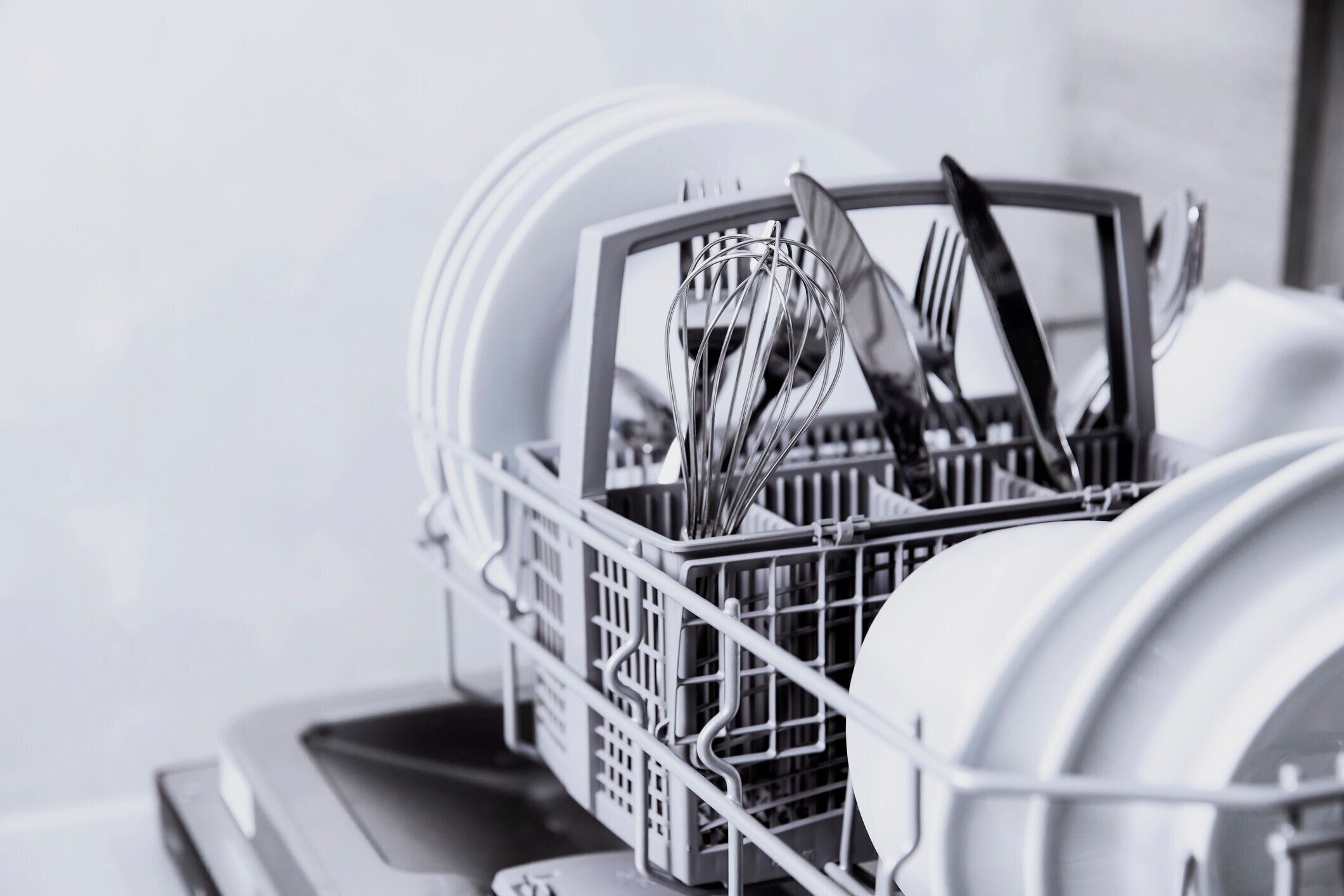 キッチンで清潔な食器、カトラリー、グラス、食器を入れたオープン食器洗い機