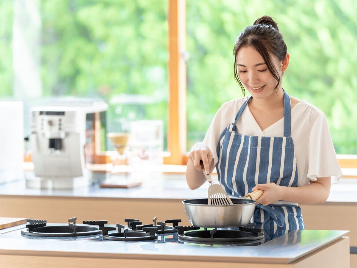 キッチンで調理魅力的な日本人女性