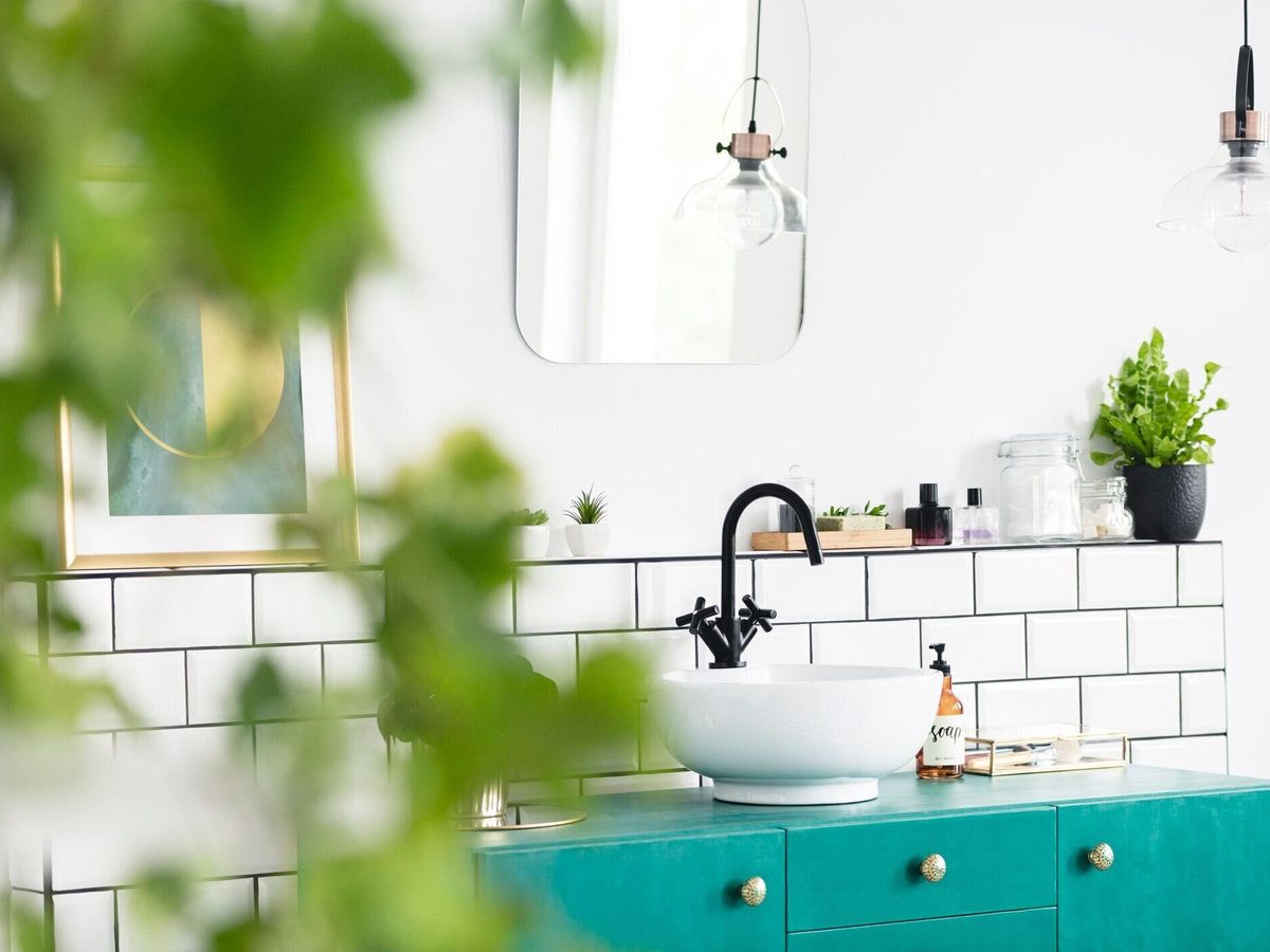 シンク、緑の食器棚、浴室内部のバック グラウンドでミラーとぼやけて葉のクローズ アップ。実際の写真