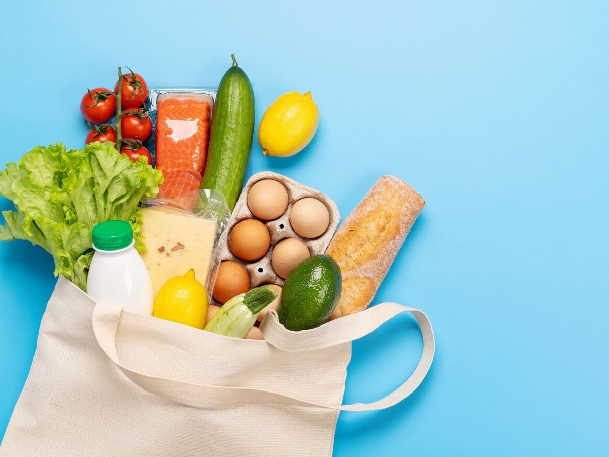 青の背景に健康食品でいっぱいのショッピングバッグ