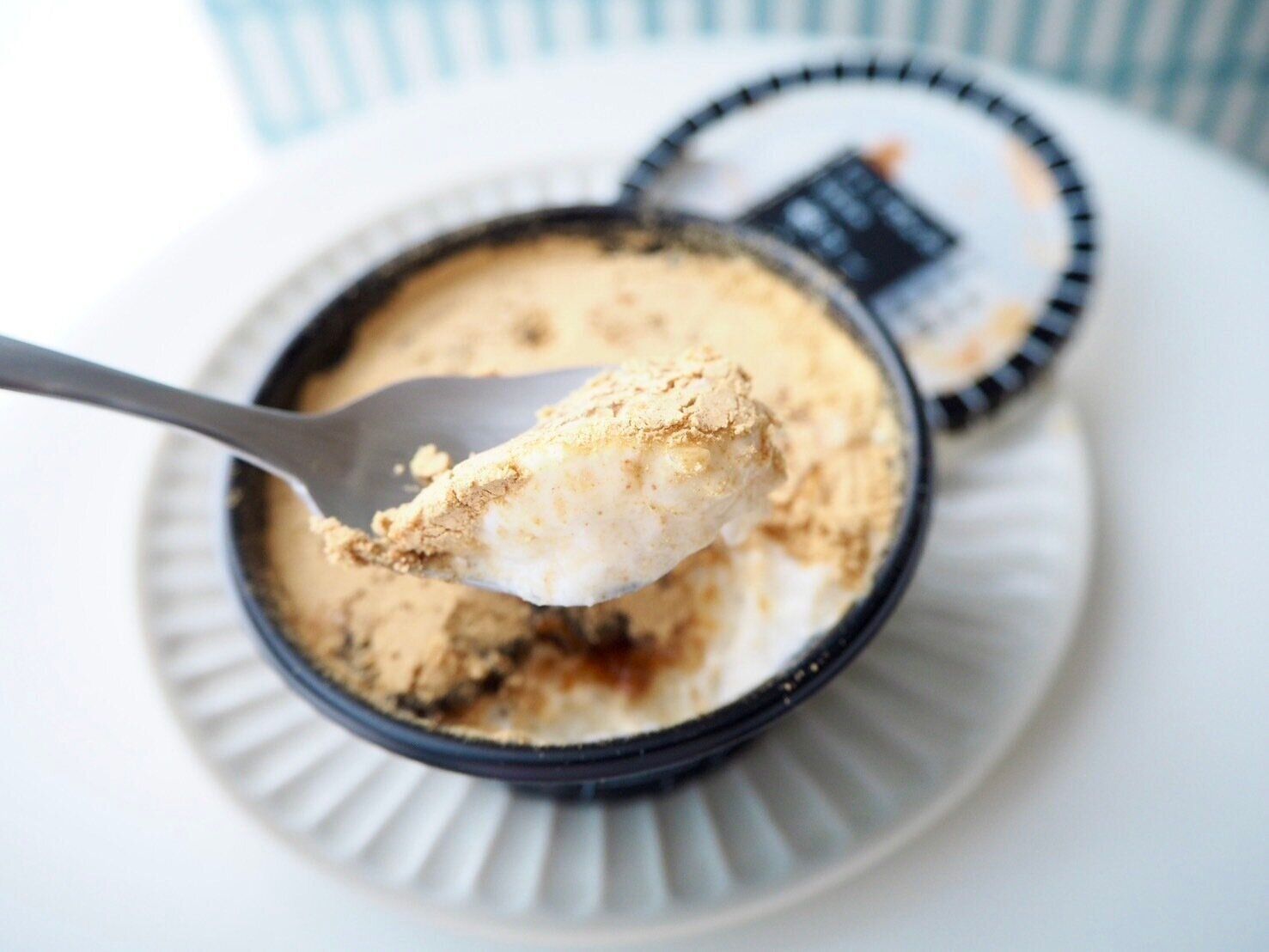 シャトレーゼ「白州名水かき氷Premium やわらか練乳氷 香ばしきなこ 北海道産あずき＆黒蜜使用」スプーンのせ写真