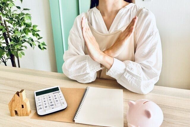 手でバツを作る女性