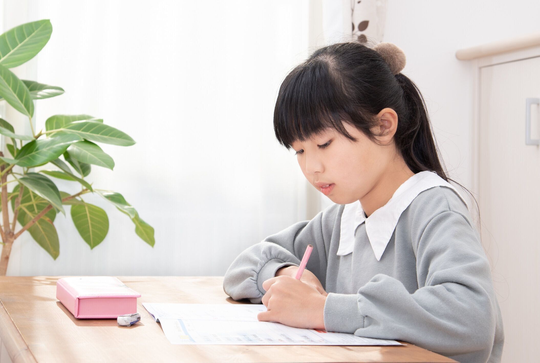 リビングルームで宿題をしている日本の小学生