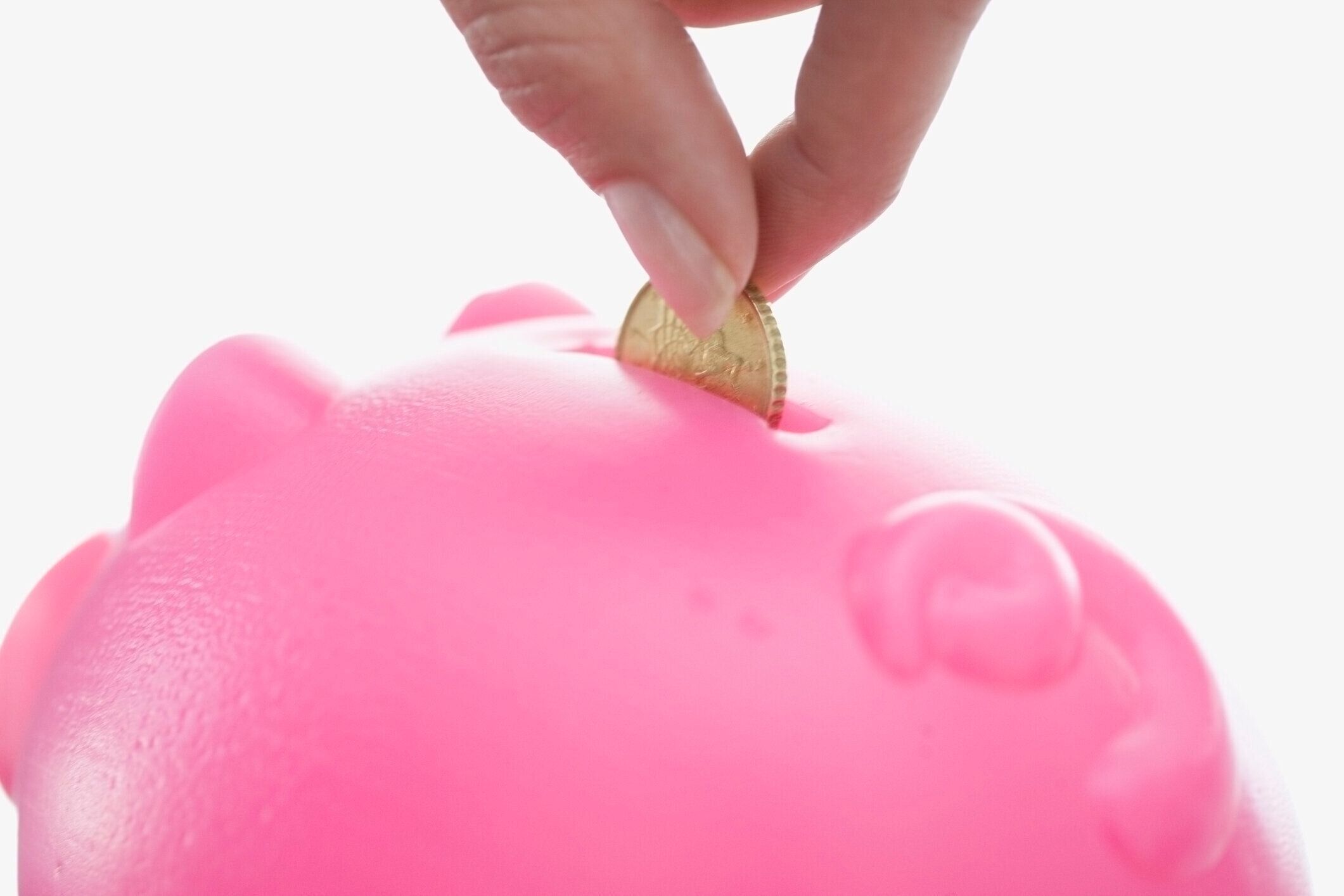 女性のクローズアップフィーディングピギー銀行