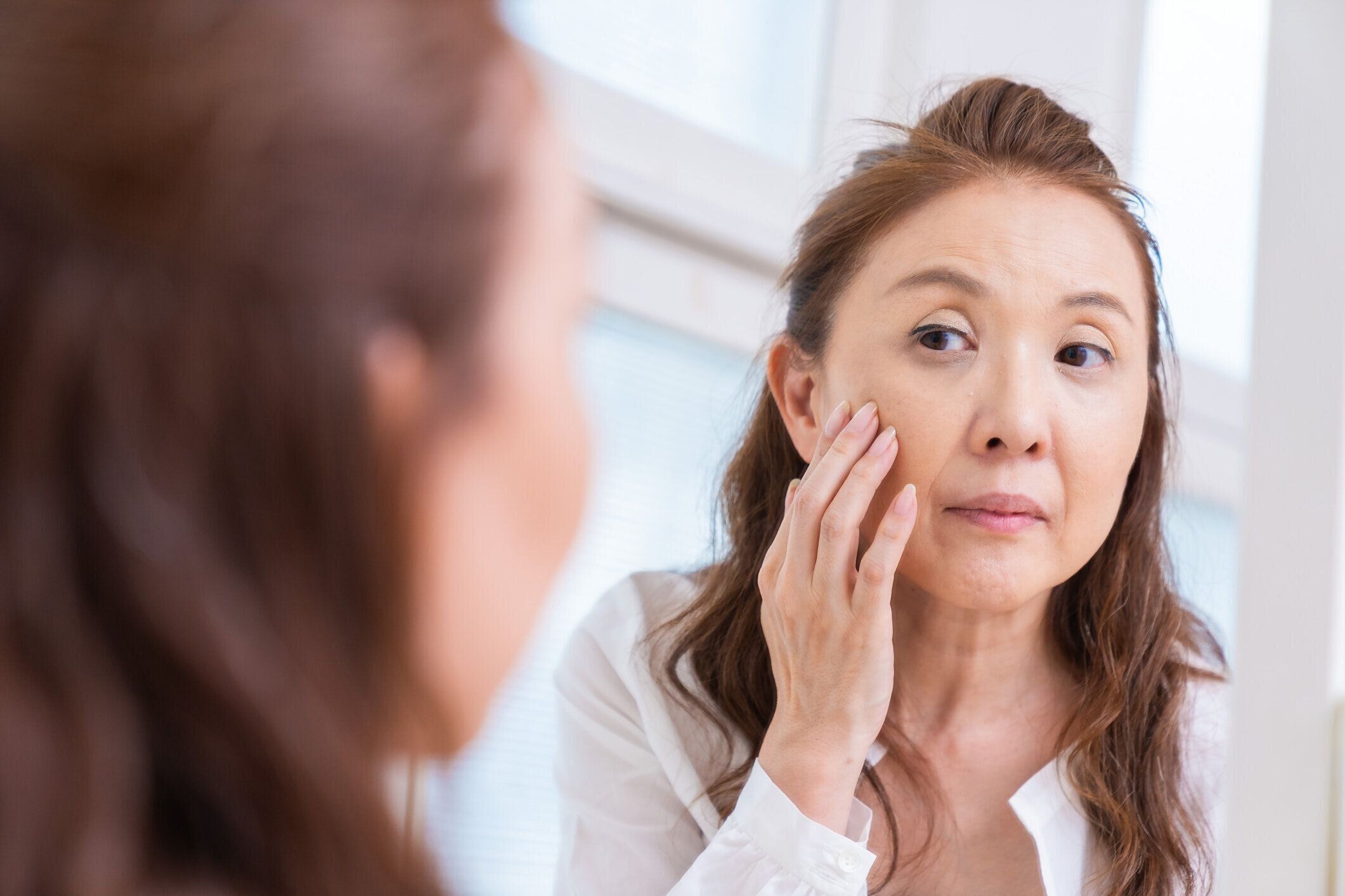 鏡を見る年上の女性
