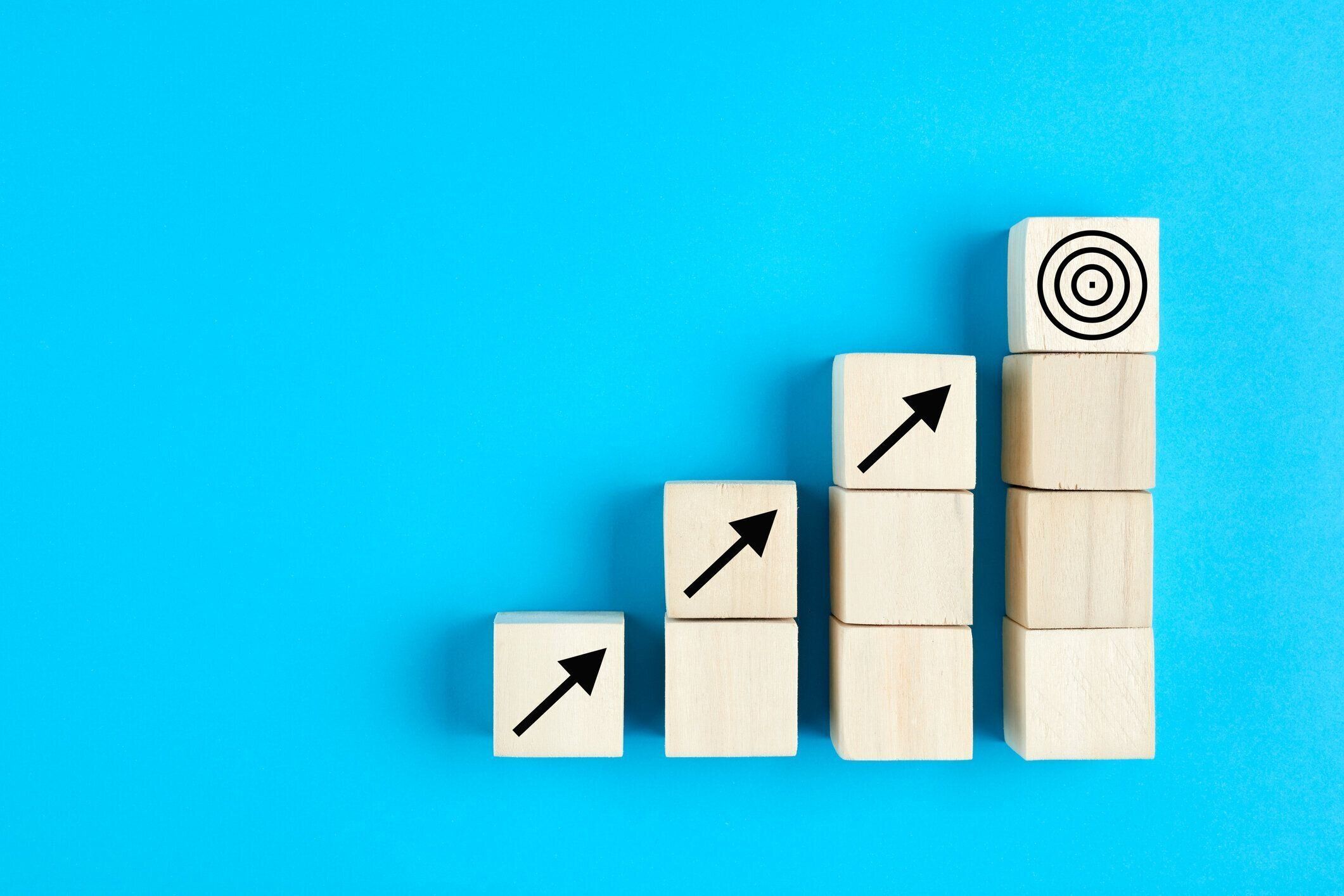 木製キューブ上の矢印アイコンを持つビジネスまたは経済成長の概念