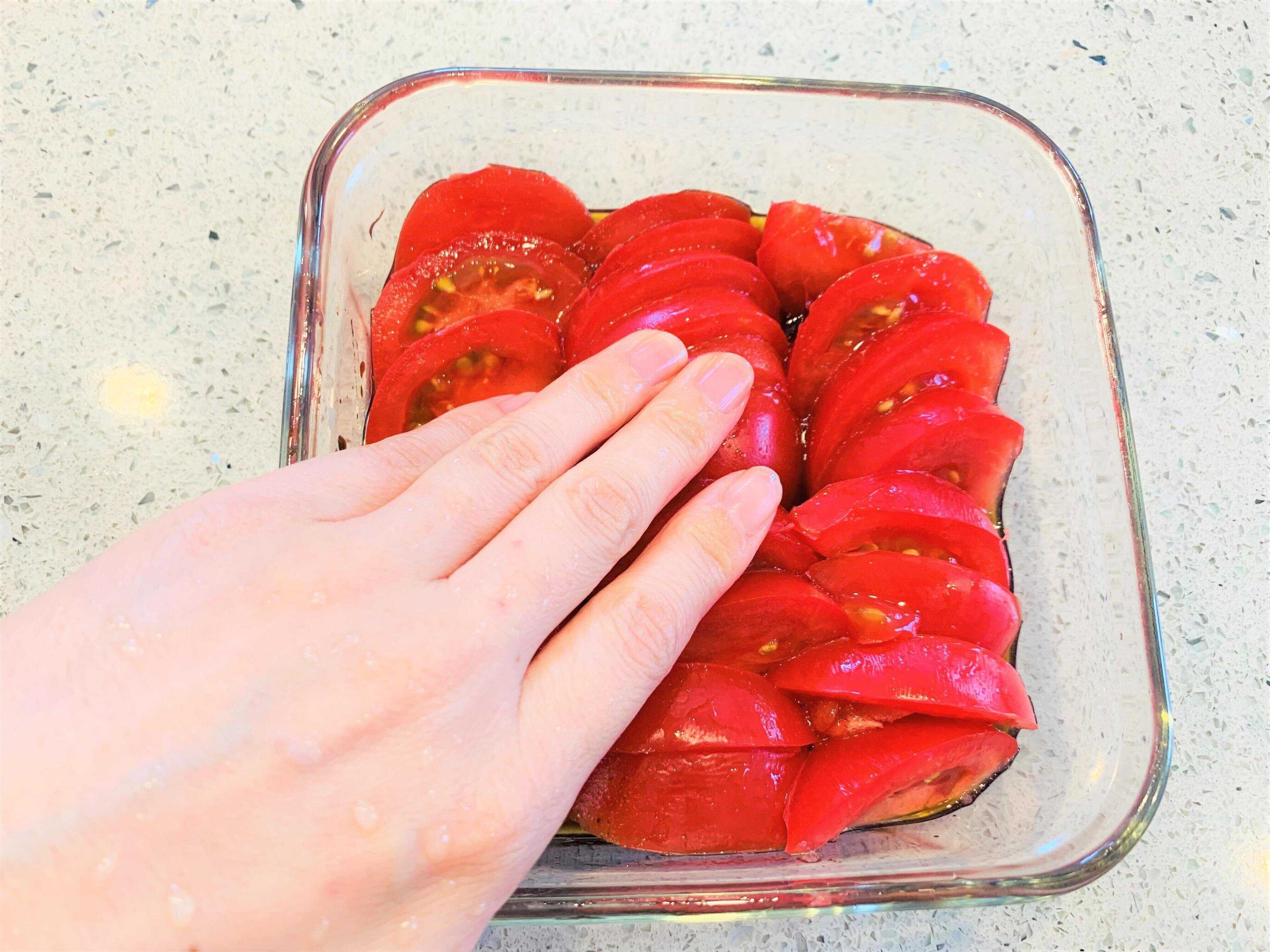 切ったトマトを入れて馴染ませる様子