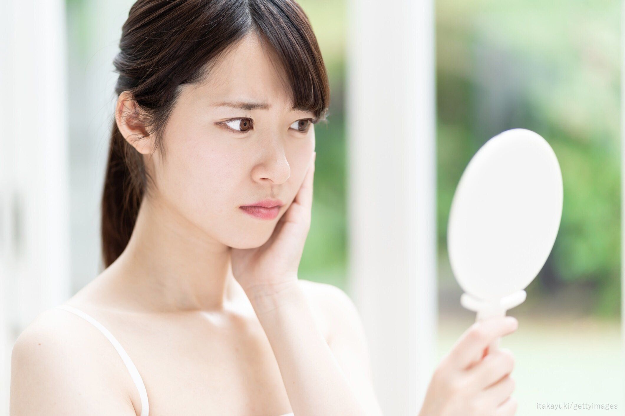 手鏡を見る女性