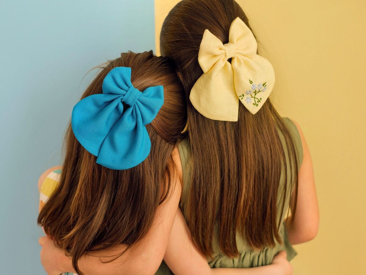 青と黄色の弓を持つ女の子が背中を抱きしめて立っている