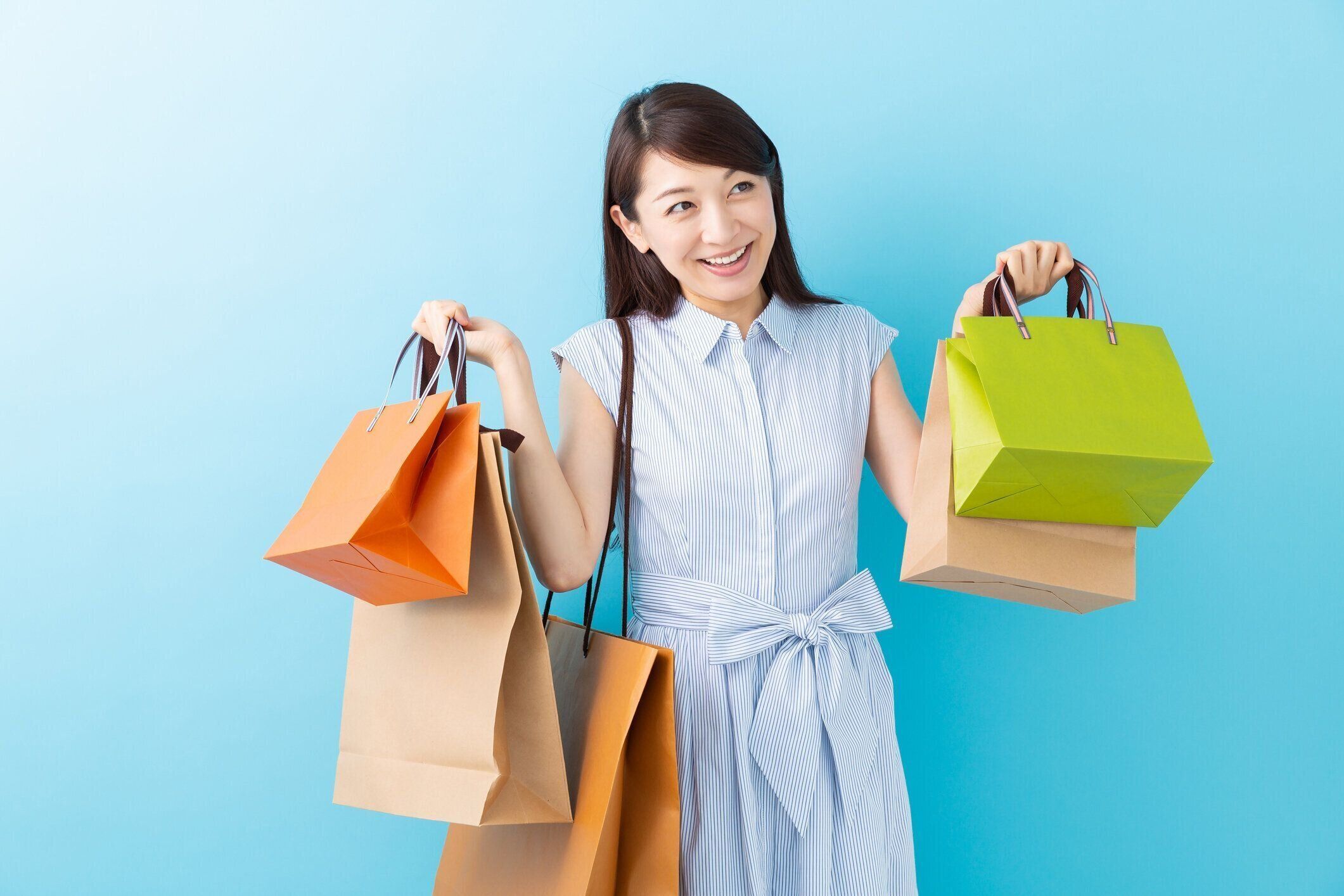 買い物袋を持っているアジアの女性