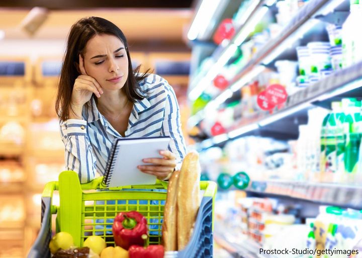 メモをみて悩む買い物女性