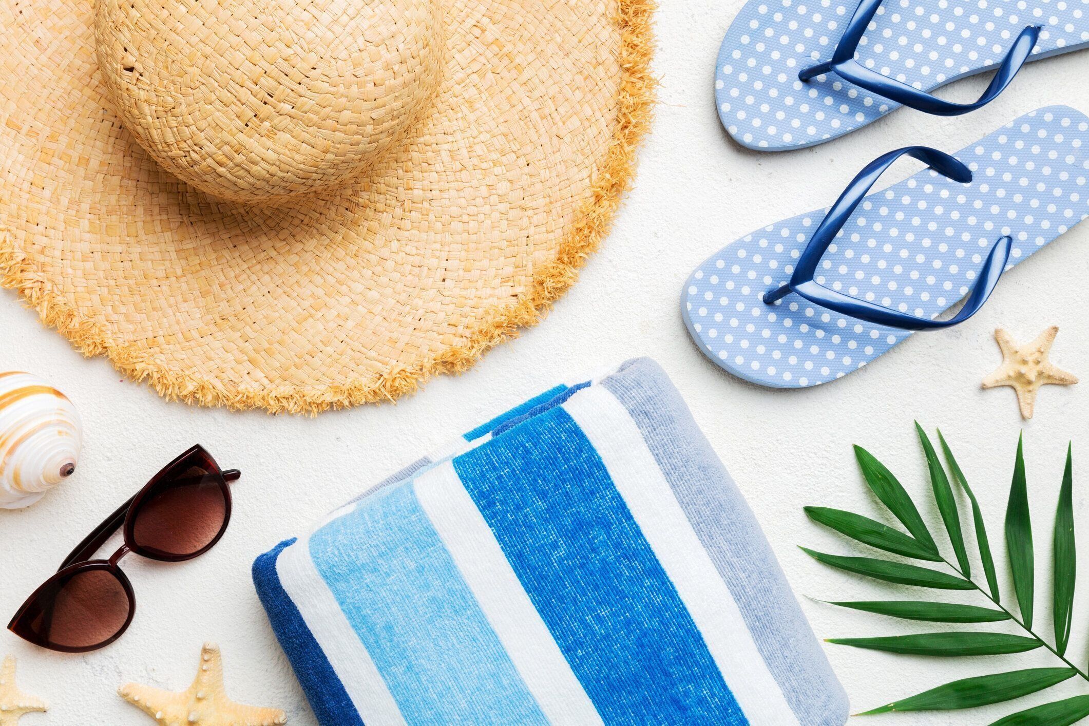 夏休みコンセプトフラットレイ。ビーチアクセサリーとタオルの上面図。テキスト用のスペース。旅行コンセプト