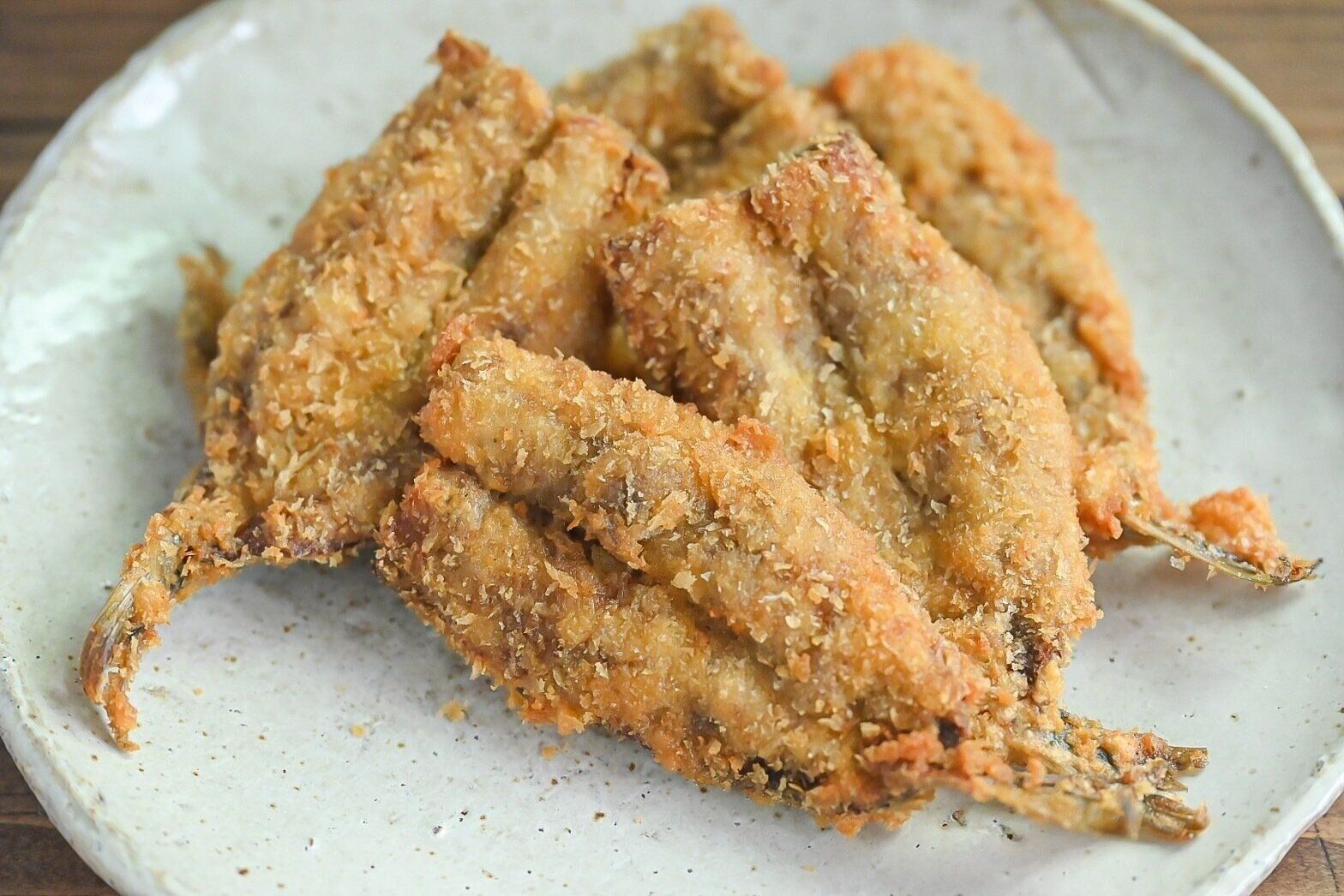 陶器の皿に盛られたいわしのフライ