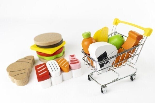 おもちゃのカートに積み木の食べ物が入っている