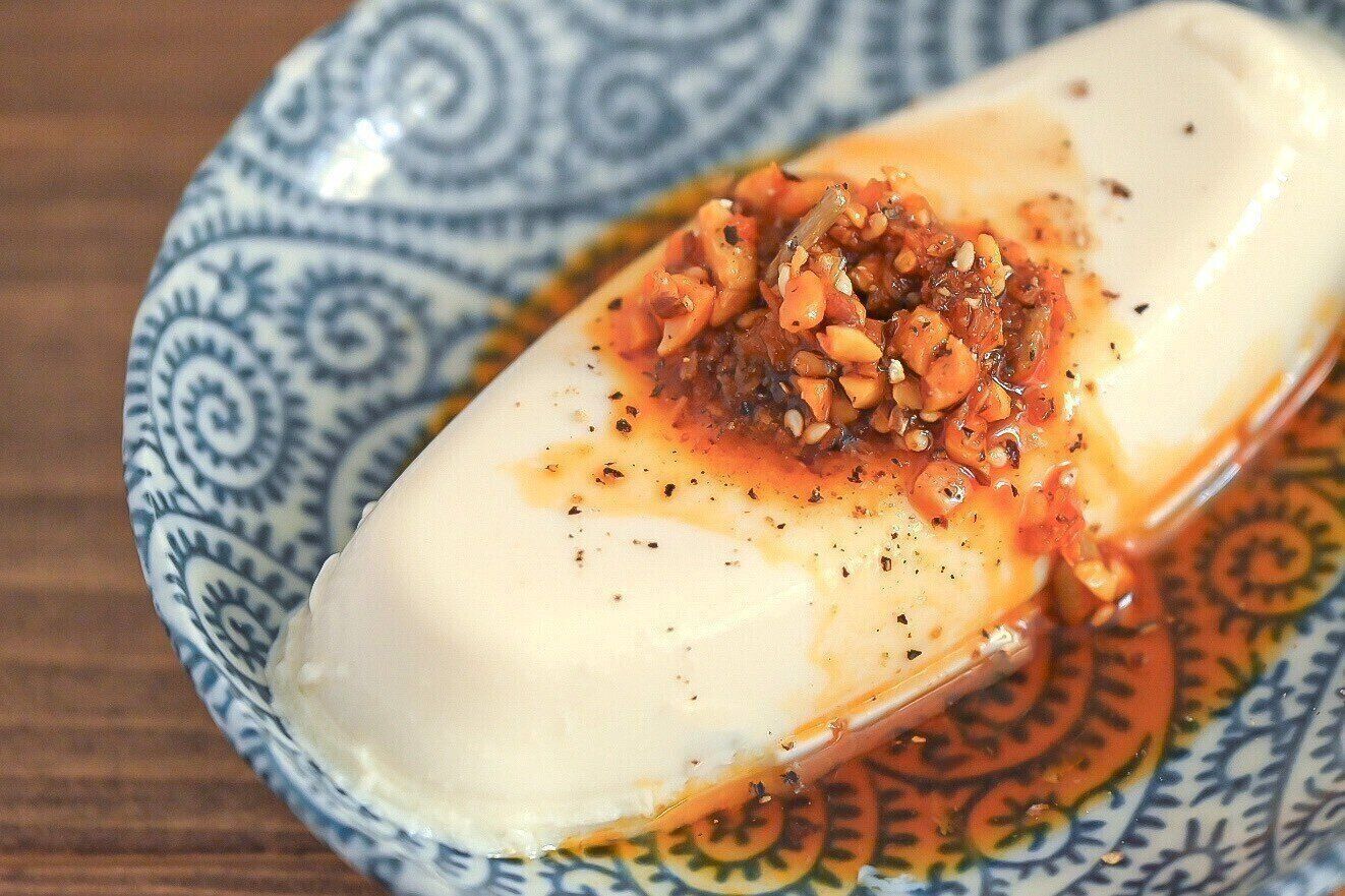 皿に盛られた食べるナッツソースのかかった豆腐