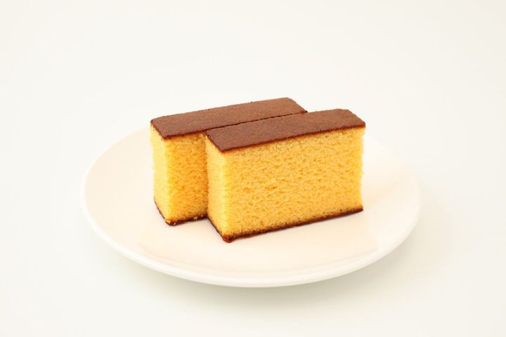 白い背景の上のプレートに日本スポンジ カステラ