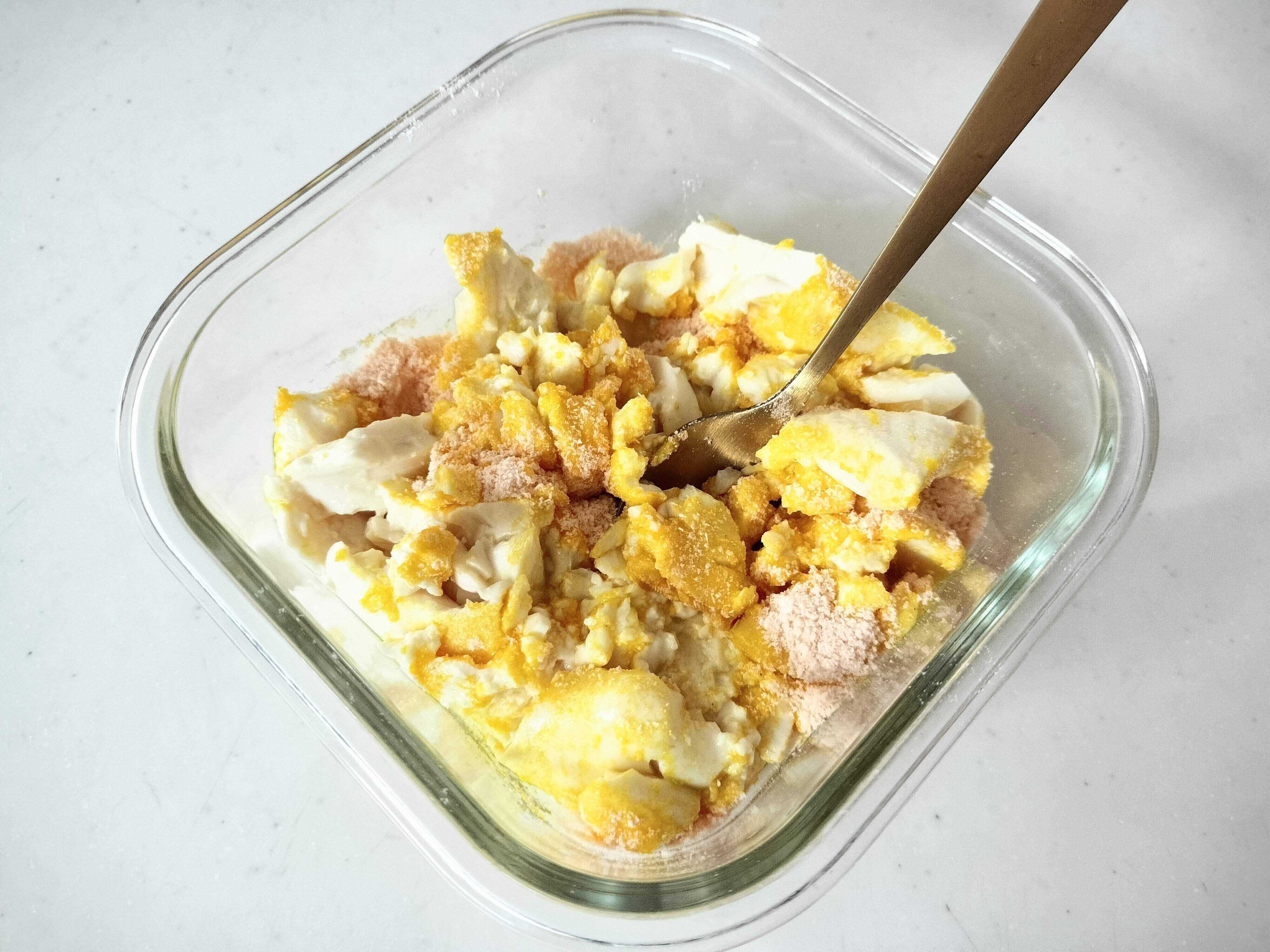 豆腐に素を入れてよく混ぜる様子