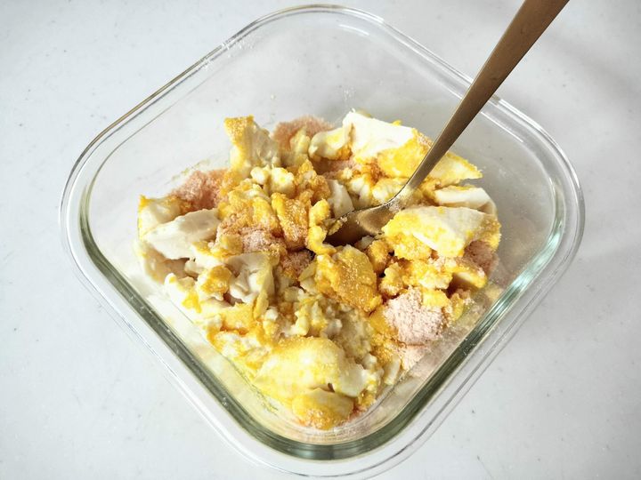 豆腐に素を入れてよく混ぜる様子