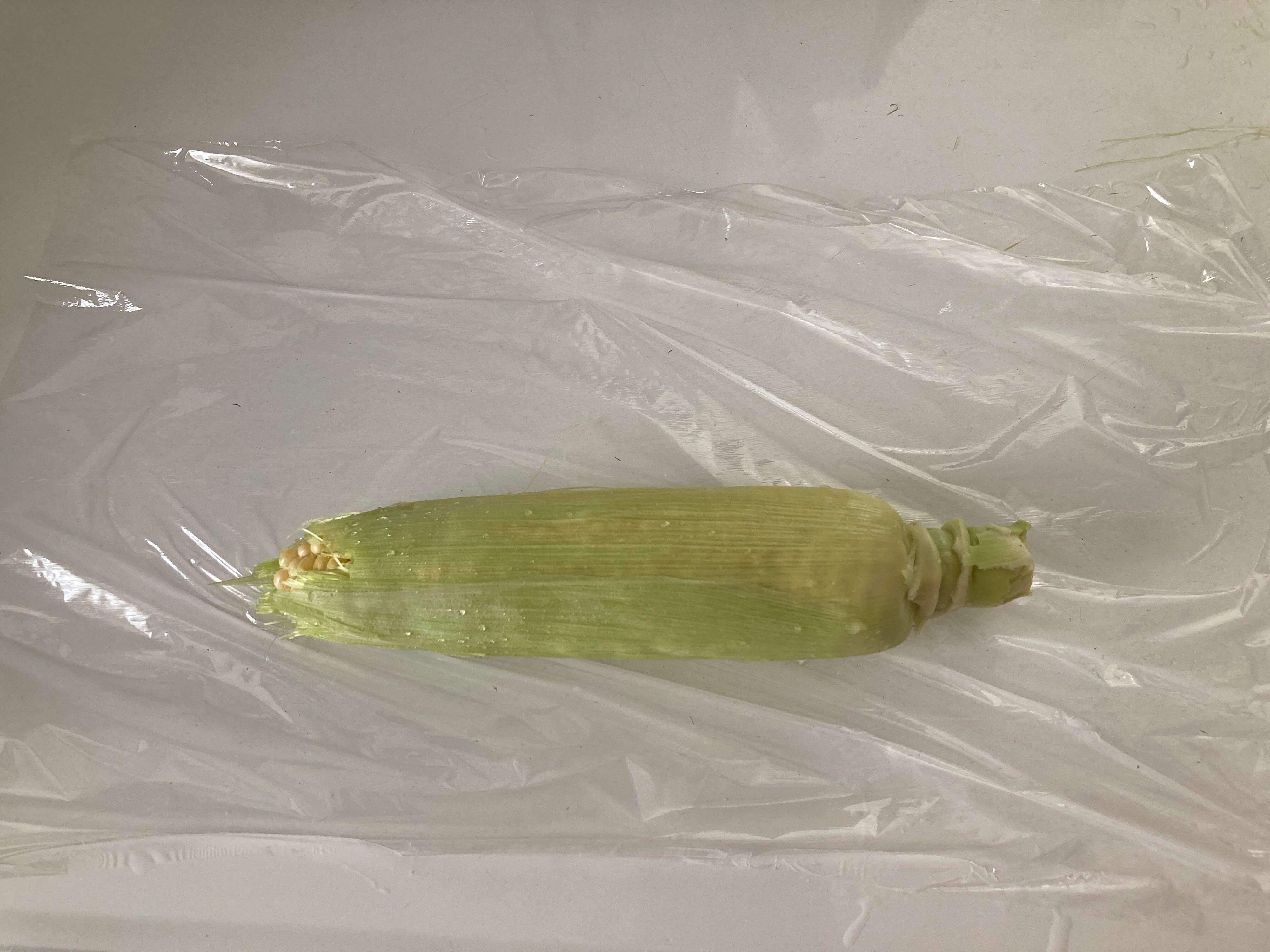 水洗いしたとうもろこしをラップで包む